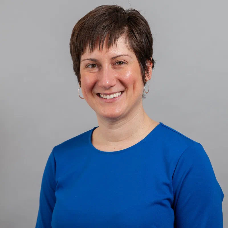 Headshot of Dr. Hannah Miller, Civilytics' first hire, smiling and looking directly at the camera. She has short brown hair and is wearing a blue shirt with hoop earrings.